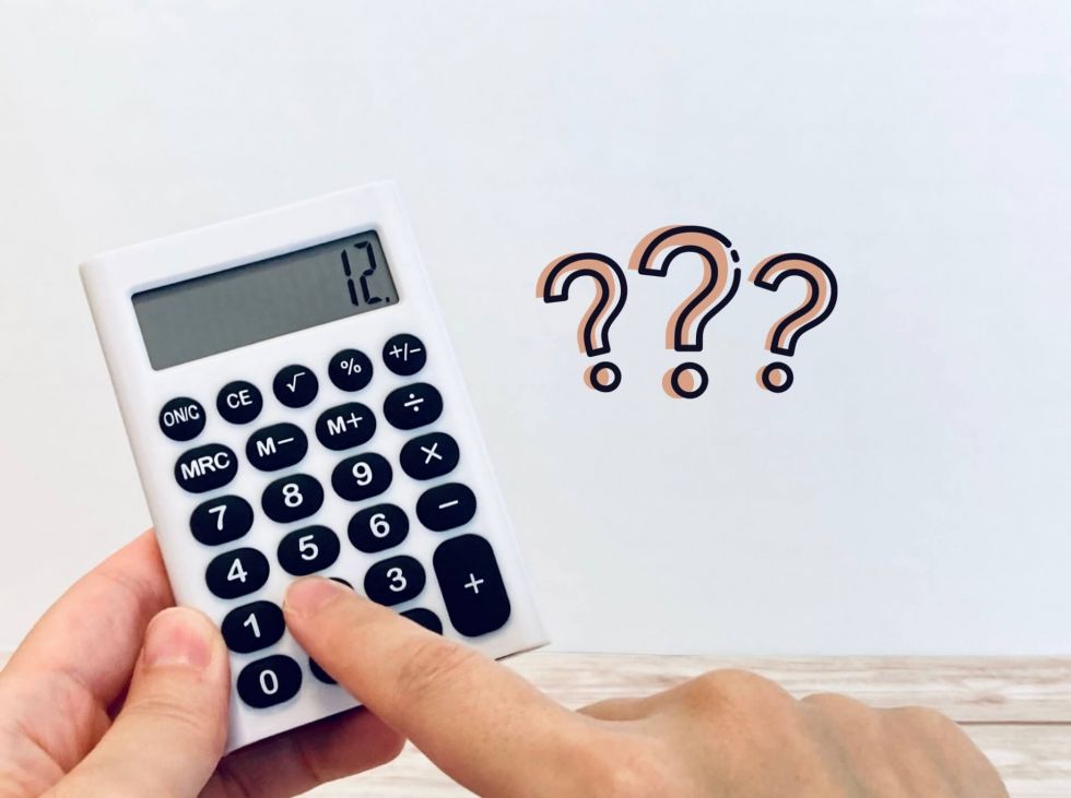 白い背景で黒い電卓と質問符