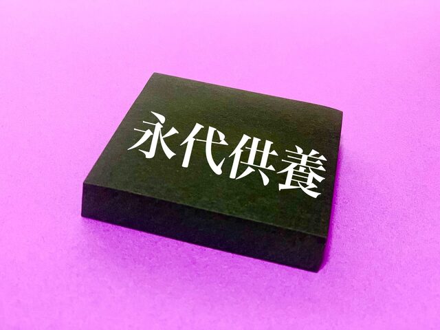 ピンク背景の黒い石に彫られた文字